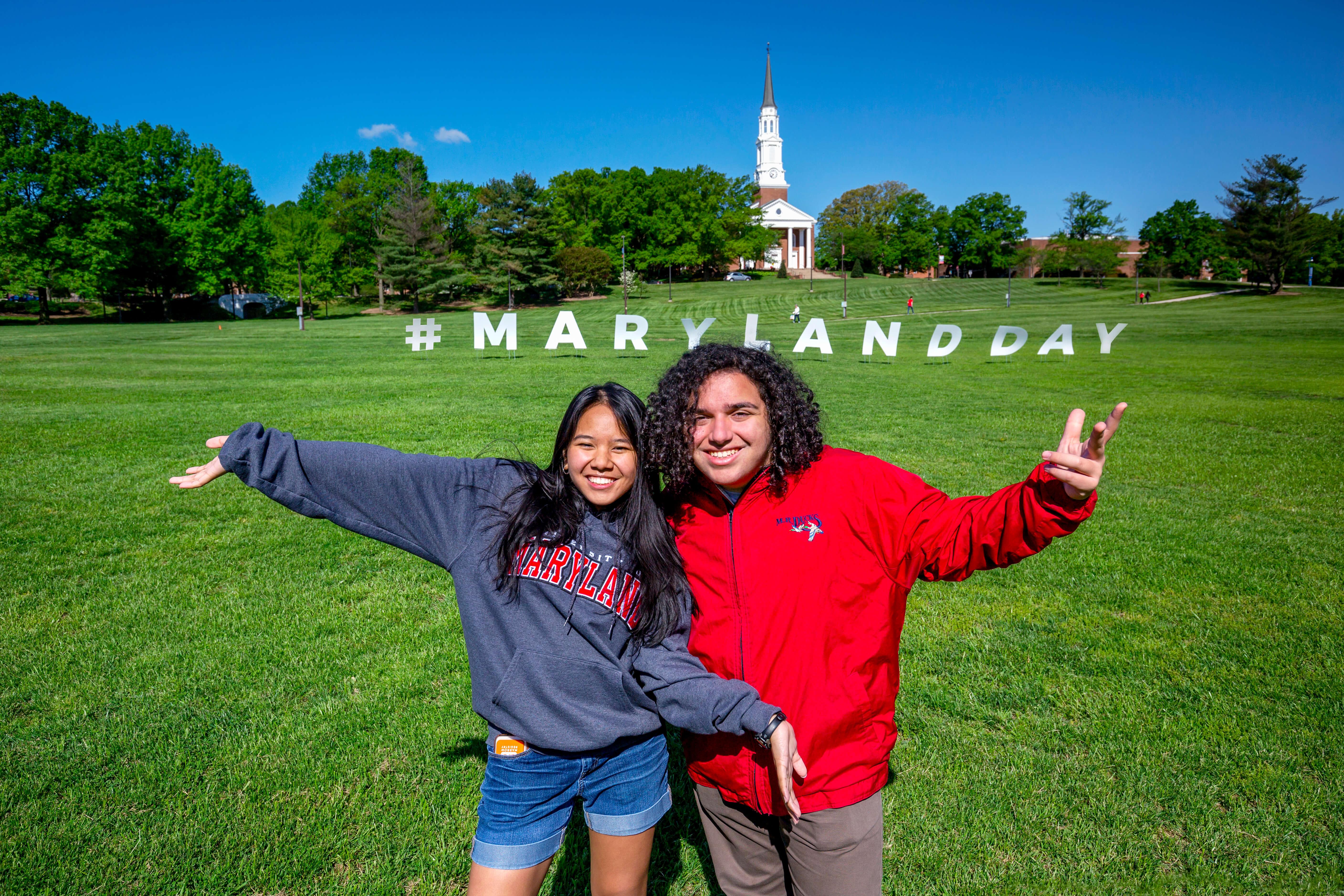 Two students on lawn with Maryland Day sign.