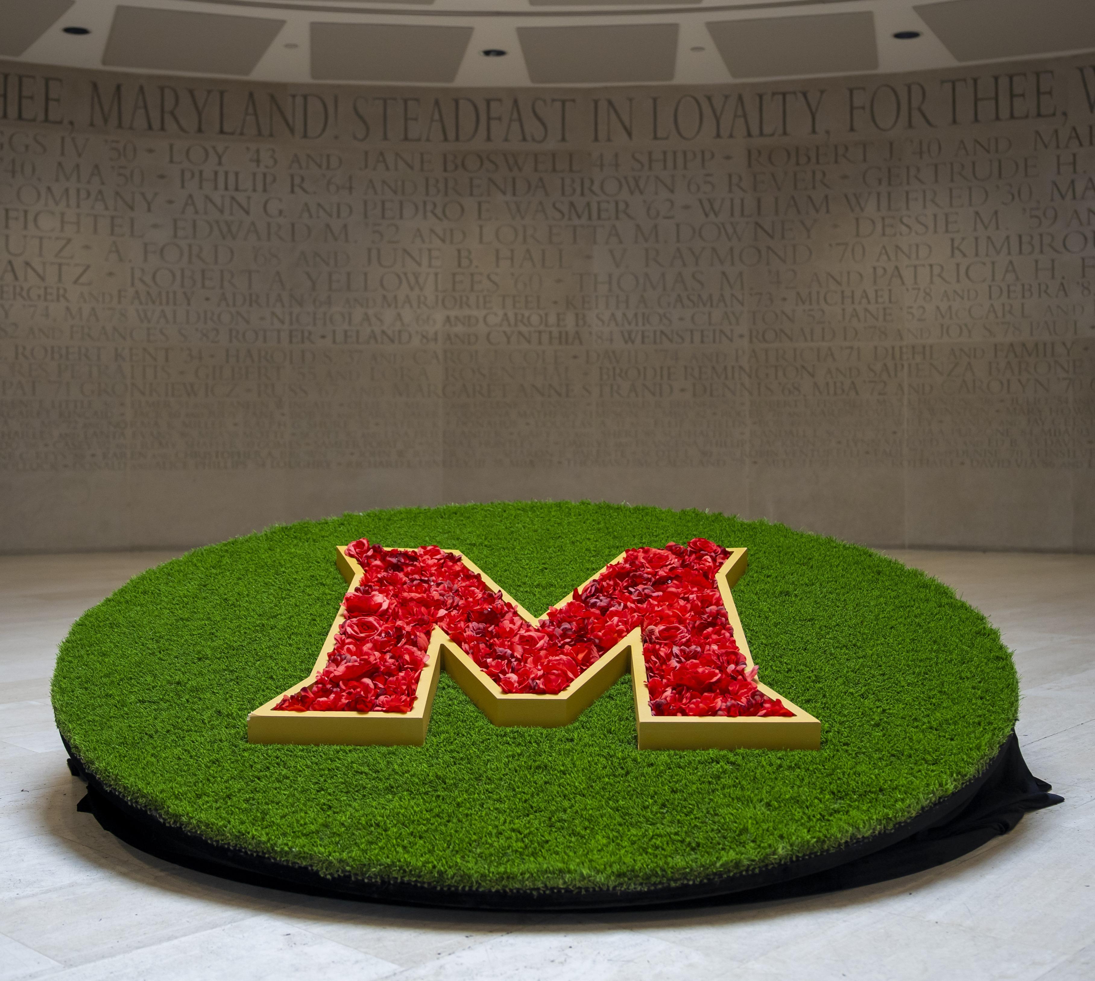 Maryland's logo of the red letter M sitting in the center of the ground floor of the Riggs Alumni Center.
